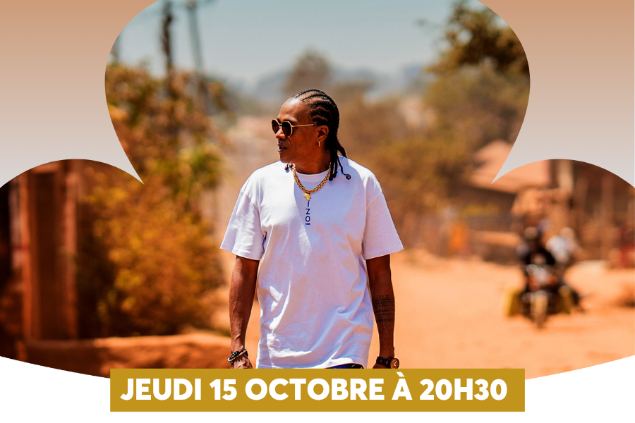 L'affiche montre un homme m�tis aux cheveux tress�s, lunettes de soleil et cha�ne dor�e, arborant un t-shirt blanc, avan�ant dans un d�cor ext�rieur flou baign� de soleil. Le visuel, encadr� de formes nuageuses stylis�es, est surmont� d'un bandeau dor� en bas affichant � JEUDI 15 OCTOBRE � 20H30 �.